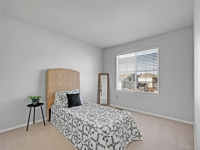 a bedroom with a bed lamp and a window