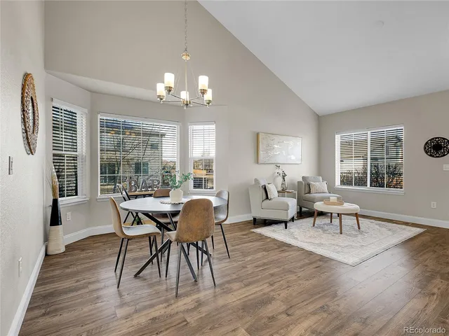 a view of a dining room with furniture a chandelier and wooden floor
