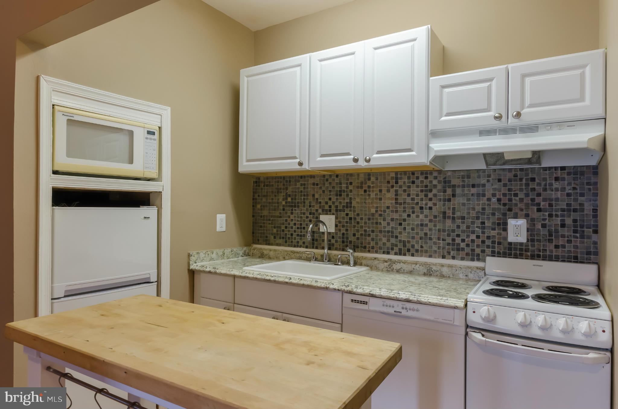 10 7th Street Northeast Washington, DC 20002 - Photo 24 of 30 a kitchen with granite countertop a sink a stove and cabinets