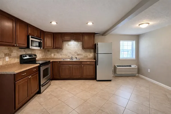a kitchen with stainless steel appliances granite countertop a stove a sink and a refrigerator