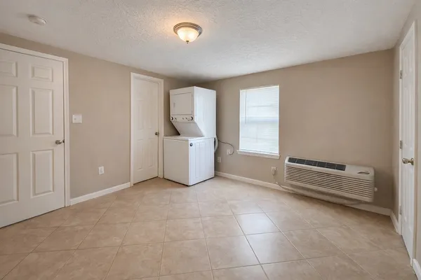 an empty room with kitchen and window