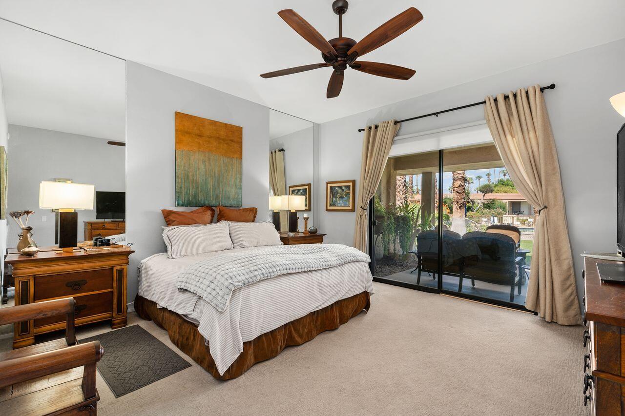 45475 Pueblo Road Indian Wells, CA 92210 - Photo 14 of 30 a bedroom with a large bed and a chandelier fan