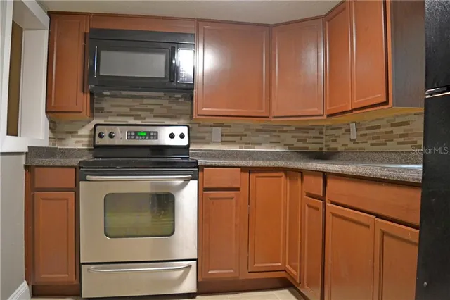 a kitchen with granite countertop cabinets stainless steel appliances and a sink