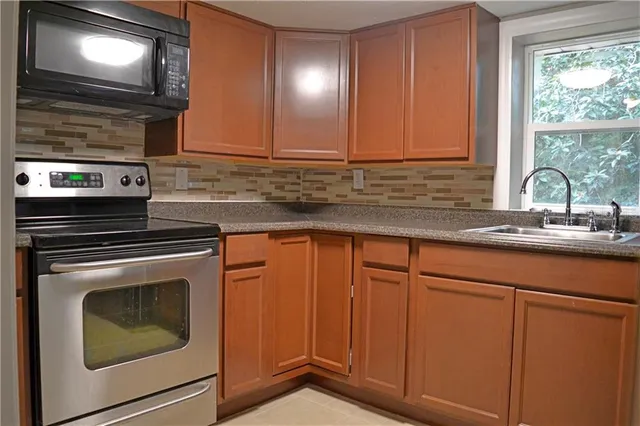 a kitchen with granite countertop cabinets stainless steel appliances and sink