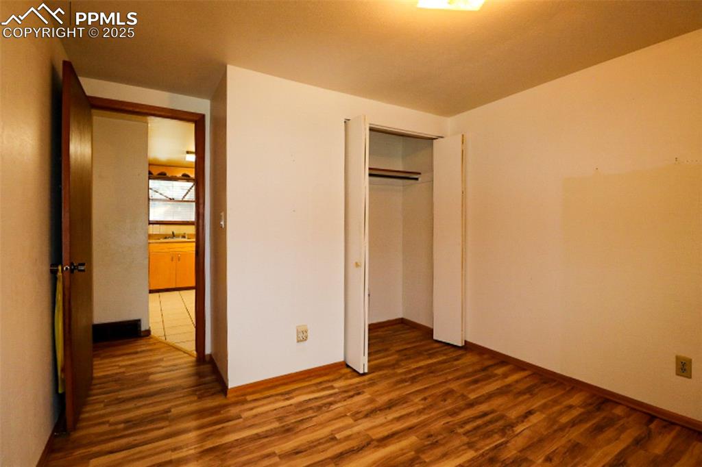 1206 Hartford Street Colorado Springs, CO 80906 - Photo 20 of 24 a view of an empty room with wooden floor and a window