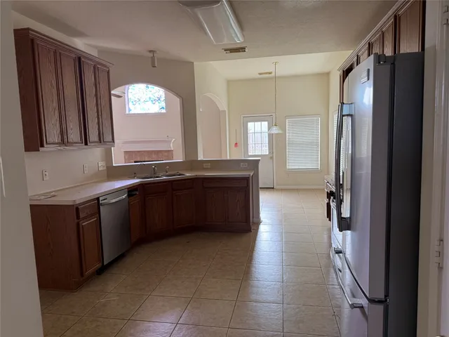 a large kitchen with a sink and a large mirror