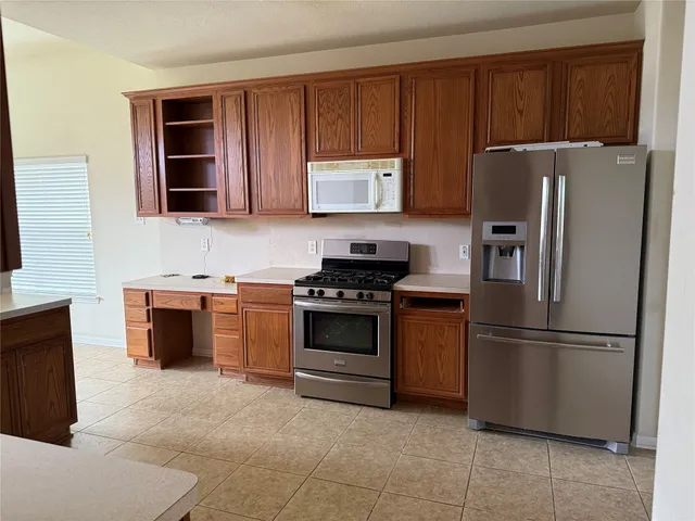 a kitchen with stainless steel appliances granite countertop a refrigerator stove and microwave