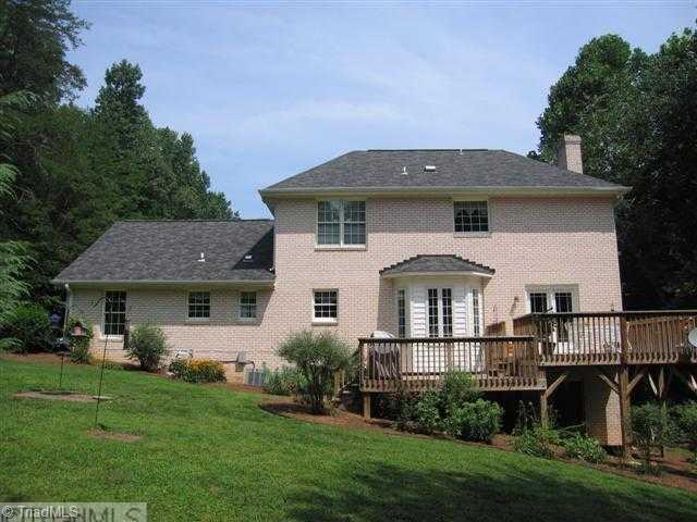 7293 Lee's Ridge Road Oak Ridge, NC 27310 - Photo 14 of 16 Exterior Back. View from the back shows off the two tiered deck, walk out basement and beautiful landscaping!