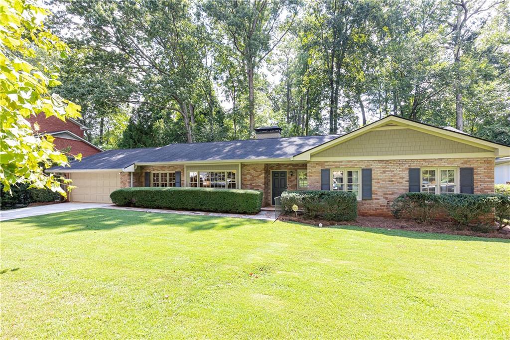 a front view of a house with yard and green space