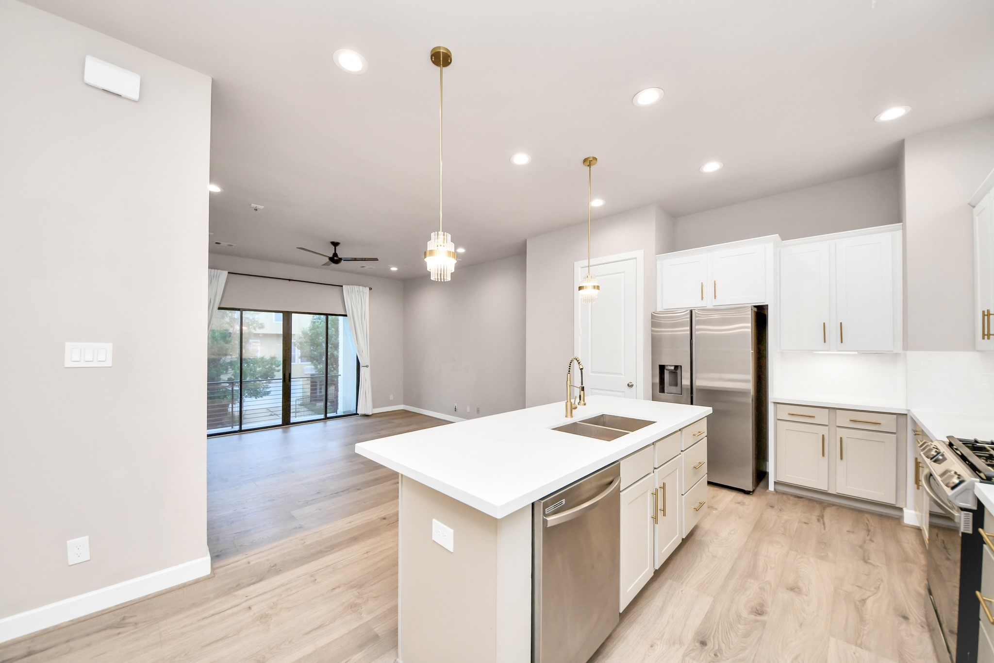2114 Stuart Street Houston, TX 77004 - Photo 17 of 39 a large white kitchen with a refrigerator a sink dishwasher and white cabinets next to a window