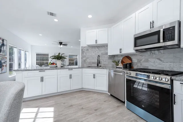 a kitchen with stainless steel appliances a stove microwave and cabinets