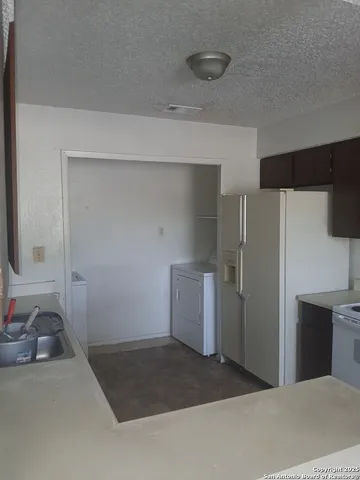 a room with a refrigerator and a sink