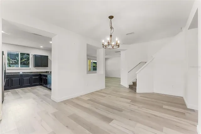 a view of a livingroom with wooden floor and kitchen space