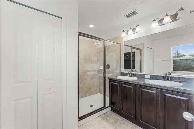 a bathroom with double vanity and a shower