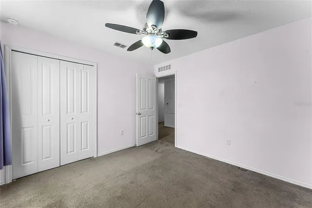 an empty room with a ceiling fan and a window
