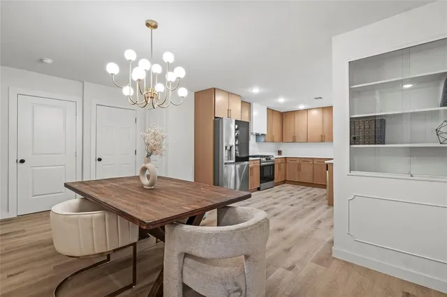 a view of kitchen with sink refrigerator dining table and chairs