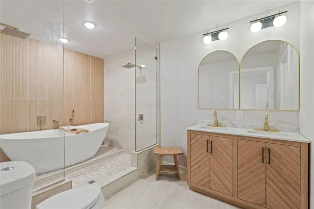 a spacious bathroom with a granite countertop sink mirror and bathtub
