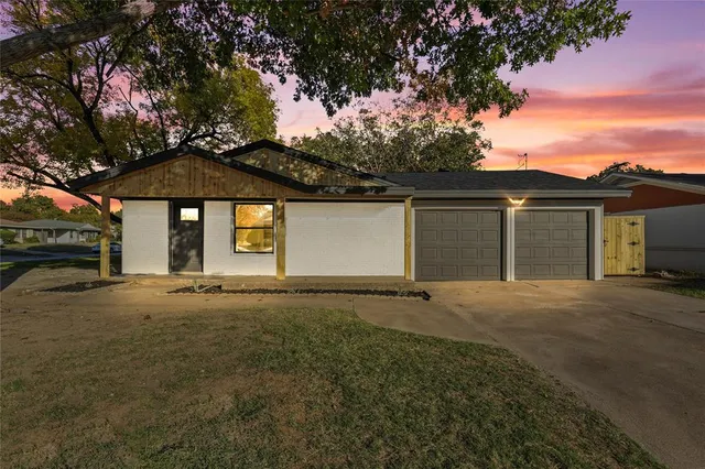 a front view of a house with yard and parking