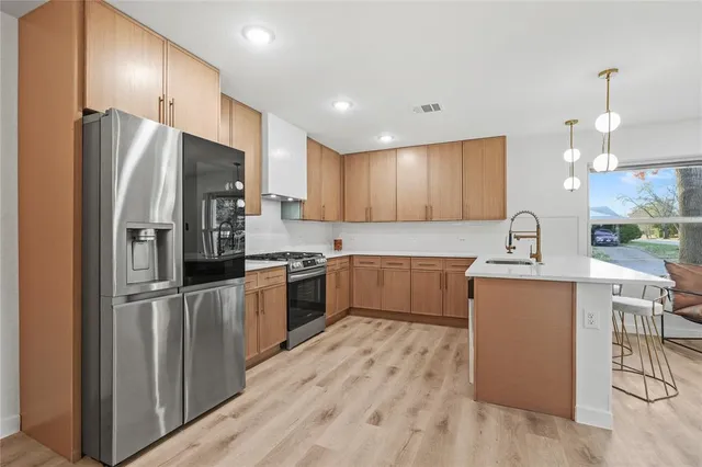 a kitchen with a refrigerator a sink and cabinets