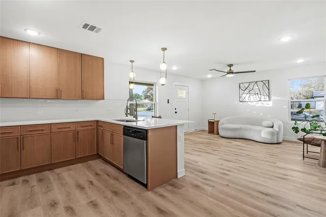 a kitchen with stainless steel appliances granite countertop a dishwasher a stove with wooden floor