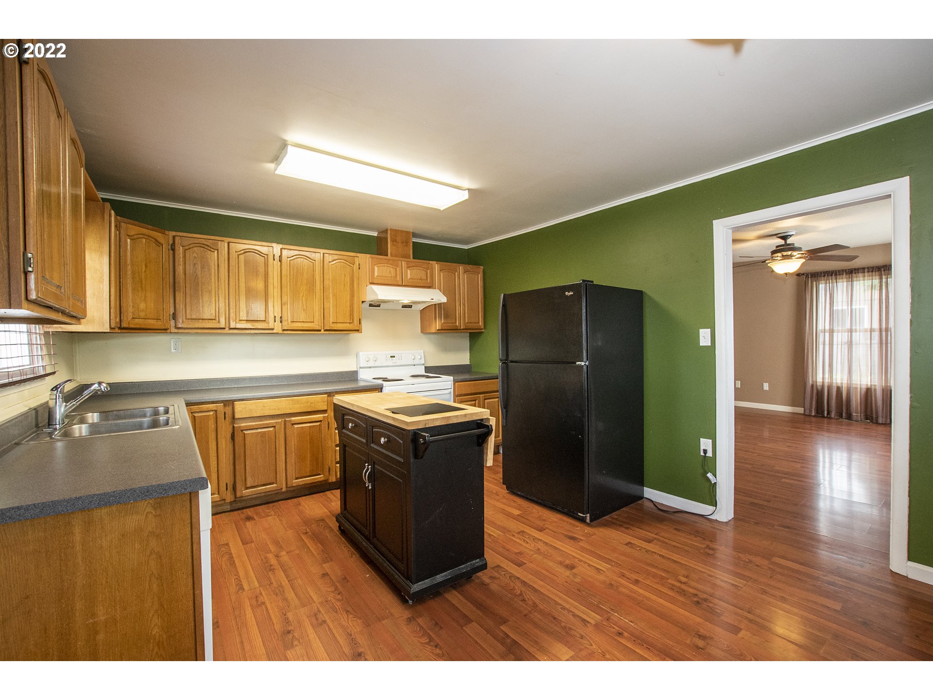 388 South 46th Street Springfield, OR 97478 - Photo 10 of 22 a kitchen with stainless steel appliances granite countertop a refrigerator a sink dishwasher and wooden cabinets with wooden floor