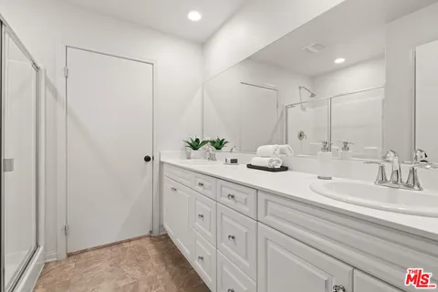 a bathroom with double sink and a mirror