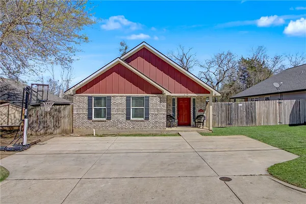 a front view of house with yard and trees in the background