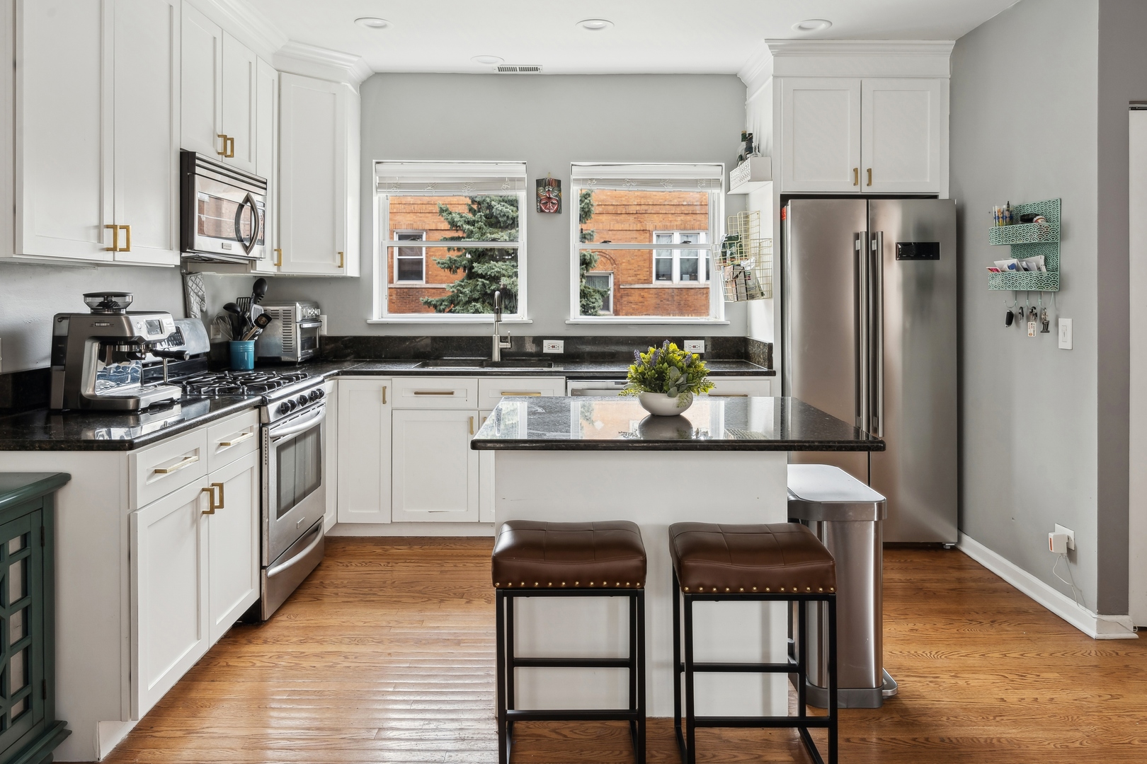 3337 West Irving Park Road, Unit 5 Chicago, IL 60618 - Photo 5 of 20 a kitchen with stainless steel appliances granite countertop white cabinets a sink and chairs