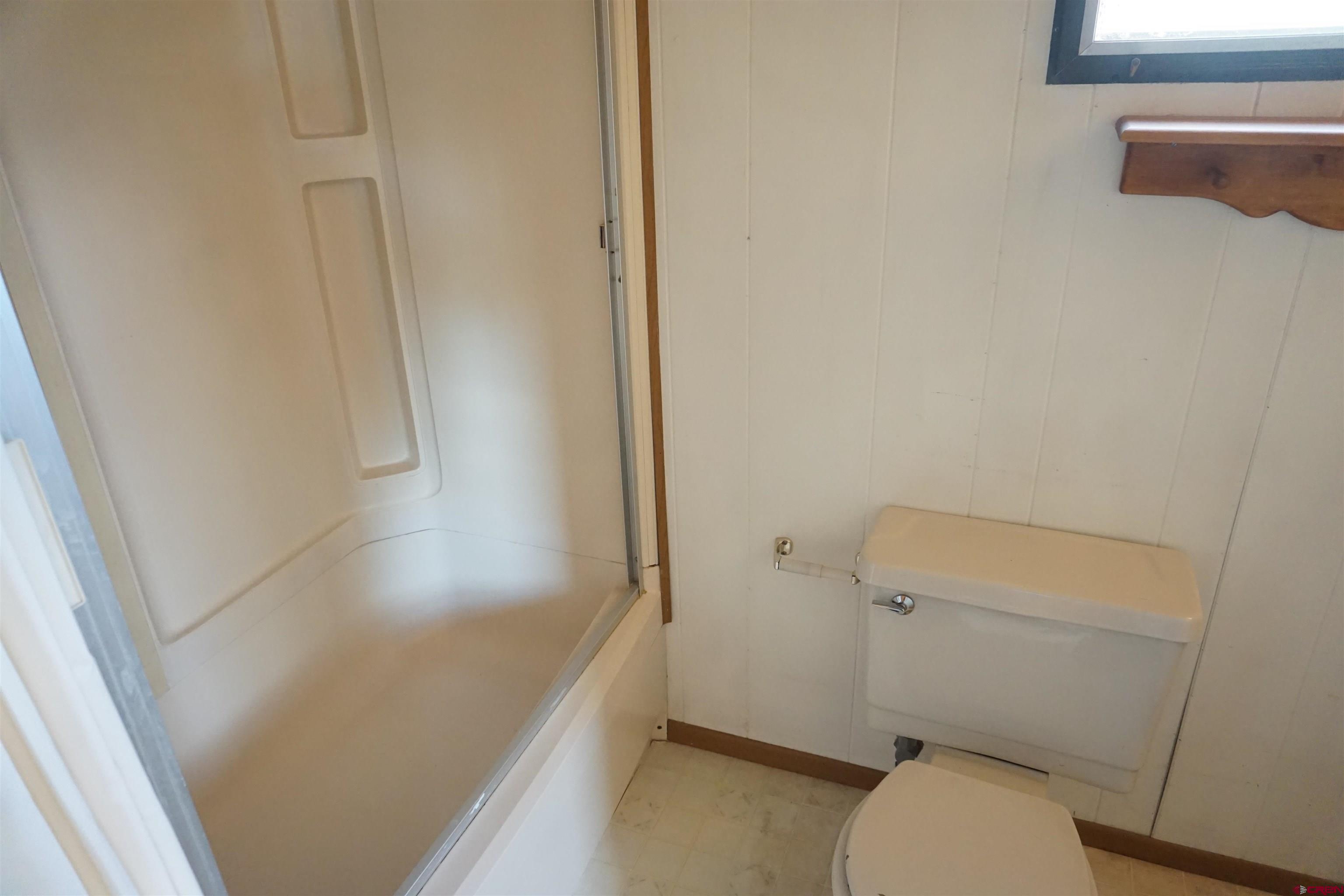 60497 Maple Grove Road Montrose, CO 81403 - Photo 12 of 16 a white toilet sitting next to a shower
