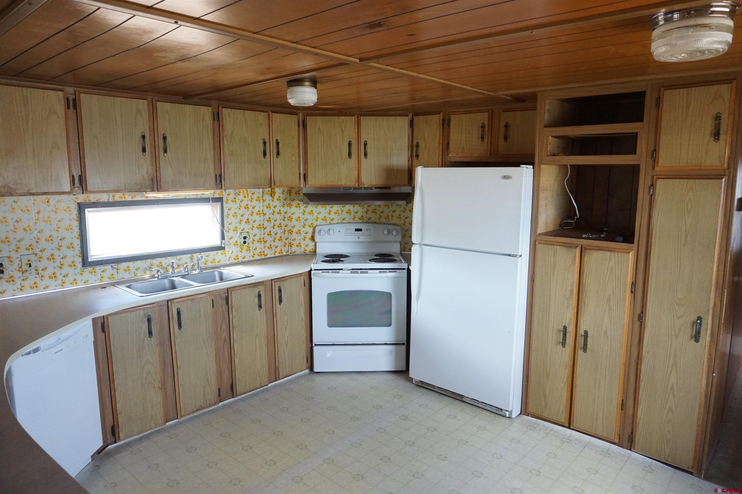 60497 Maple Grove Road Montrose, CO 81403 - Photo 7 of 16 a kitchen with a refrigerator and window