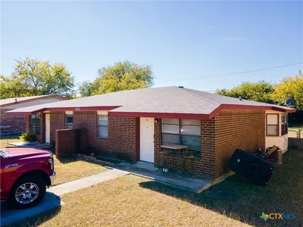 a view of a house with a backyard and a patio