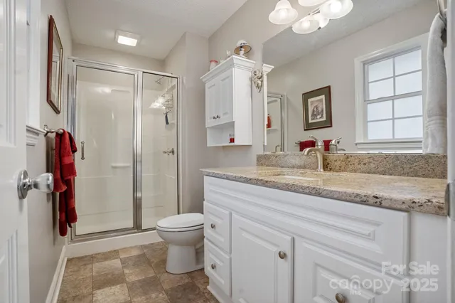 a bathroom with a granite countertop sink toilet and shower