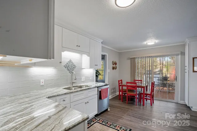 a kitchen with granite countertop sink table and chairs