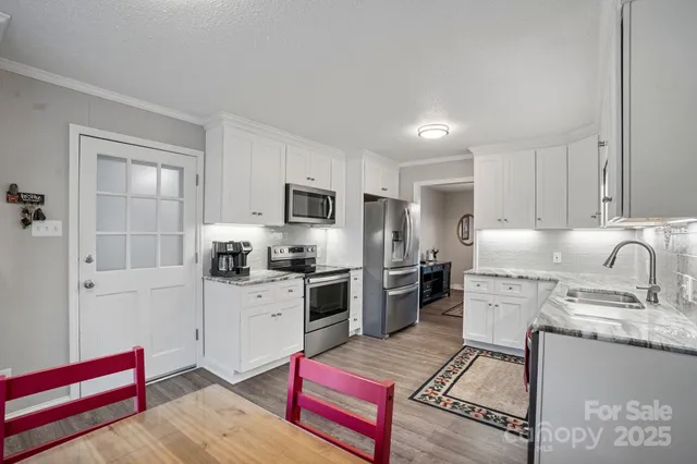 a kitchen with stainless steel appliances granite countertop a refrigerator stove microwave and sink