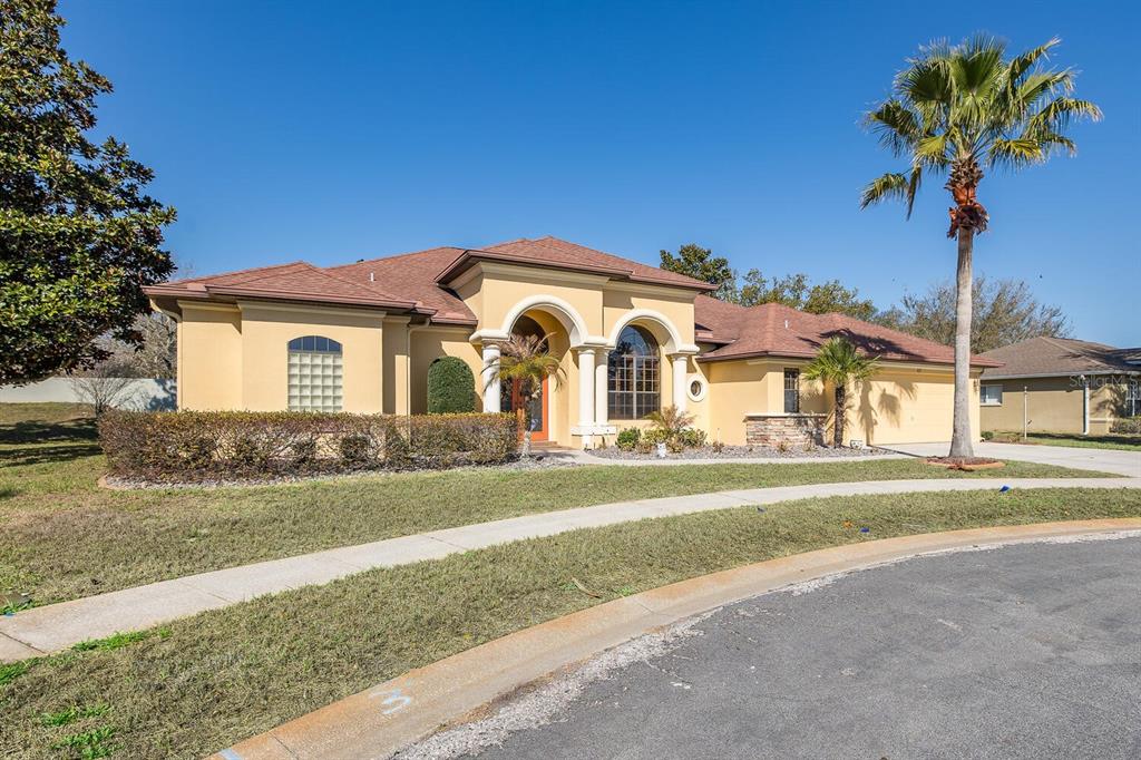 427 Archway Drive Spring Hill, FL 34608 - Photo 3 of 68 a view of a white house with a big yard and large trees
