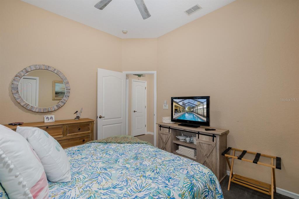 427 Archway Drive Spring Hill, FL 34608 - Photo 44 of 68 a bedroom with a bed a mirror on dresser and a chandelier