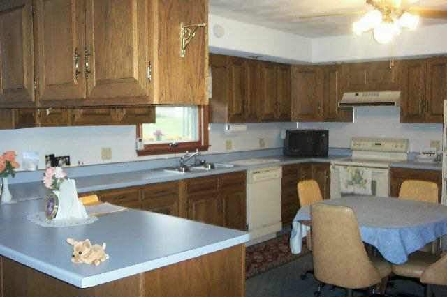 213 East Town Line Road Lena, IL 61048 - Photo 3 of 7 a kitchen with a dining table chairs and sink