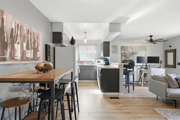 a kitchen with stainless steel appliances kitchen island granite countertop a table chairs and a refrigerator