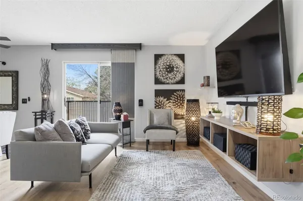 a living room with furniture a flat screen tv and a fireplace
