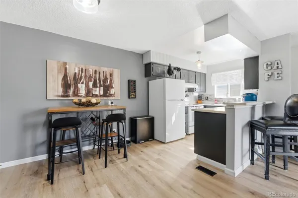 a kitchen with refrigerator a table and chairs in it