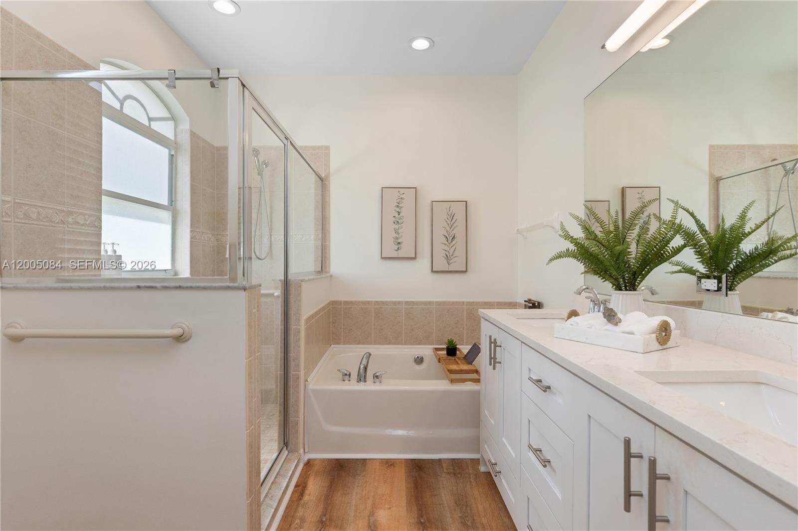 1896 Crestview Way Naples, FL 34119 - Photo 56 of 91 a bathroom with a sink a large mirror and a bathtub