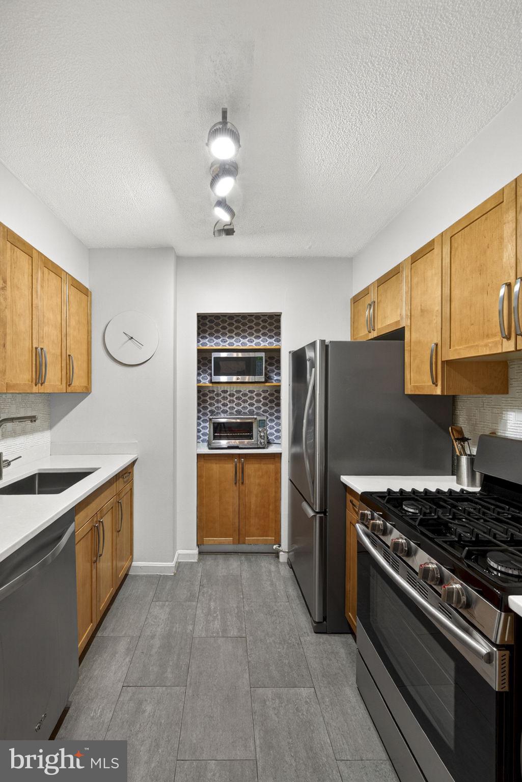 429 N Street Southwest, Unit S203 Washington, DC 20024 - Photo 7 of 28 a kitchen with stainless steel appliances granite countertop a stove and a refrigerator