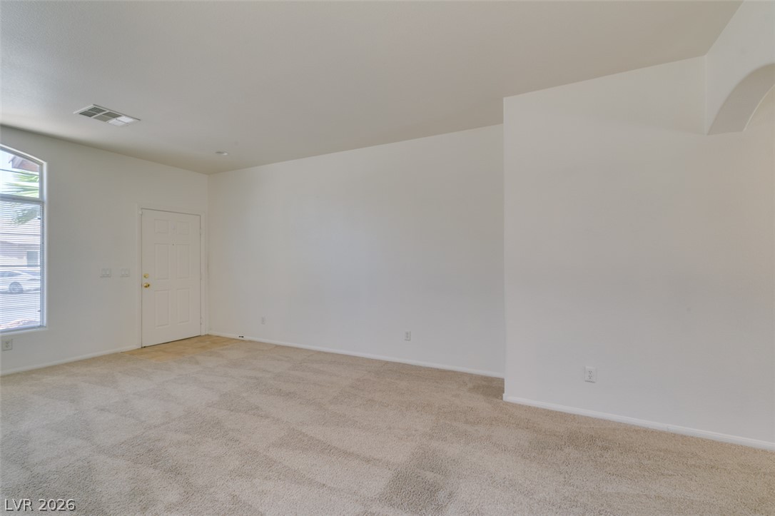 5150 Riverside Run Court North Las Vegas, NV 89081 - Photo 16 of 50 A spacious room offers comfortable carpet flooring and natural light from a well-placed window.