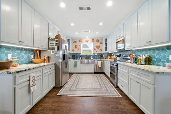 a kitchen with kitchen island granite countertop lots of counter top space sink and cabinets