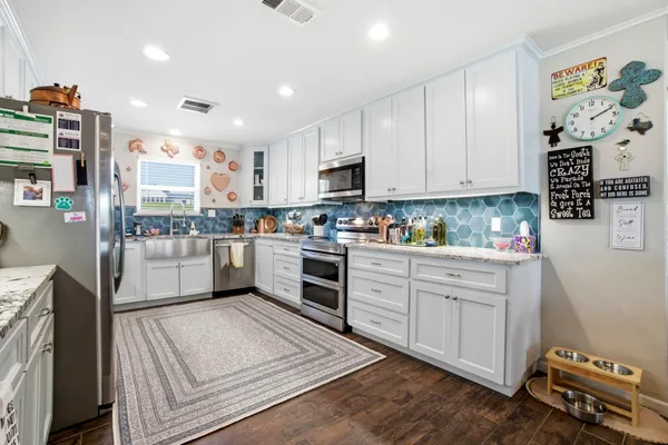 a kitchen with stainless steel appliances granite countertop a stove a sink and a refrigerator