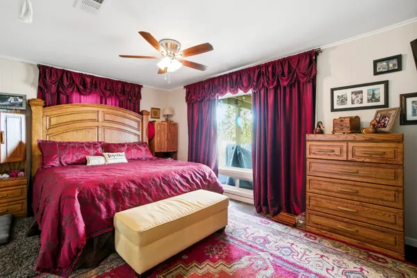 a bedroom with a bed and dresser with mirror