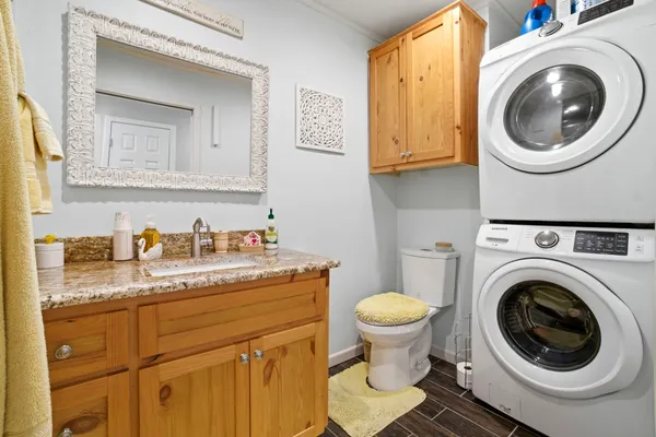 a bathroom with a granite countertop toilet sink and mirror