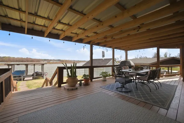 a view of a patio with a dining table and chairs with wooden floor