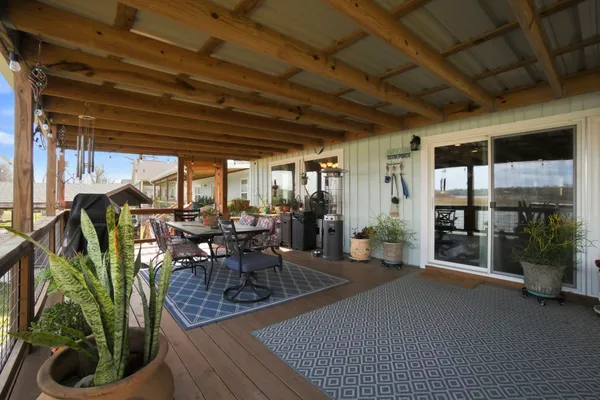 a view of a porch with chairs and potted plants