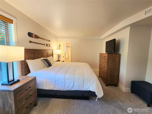 a bedroom with a bed and a flat screen tv